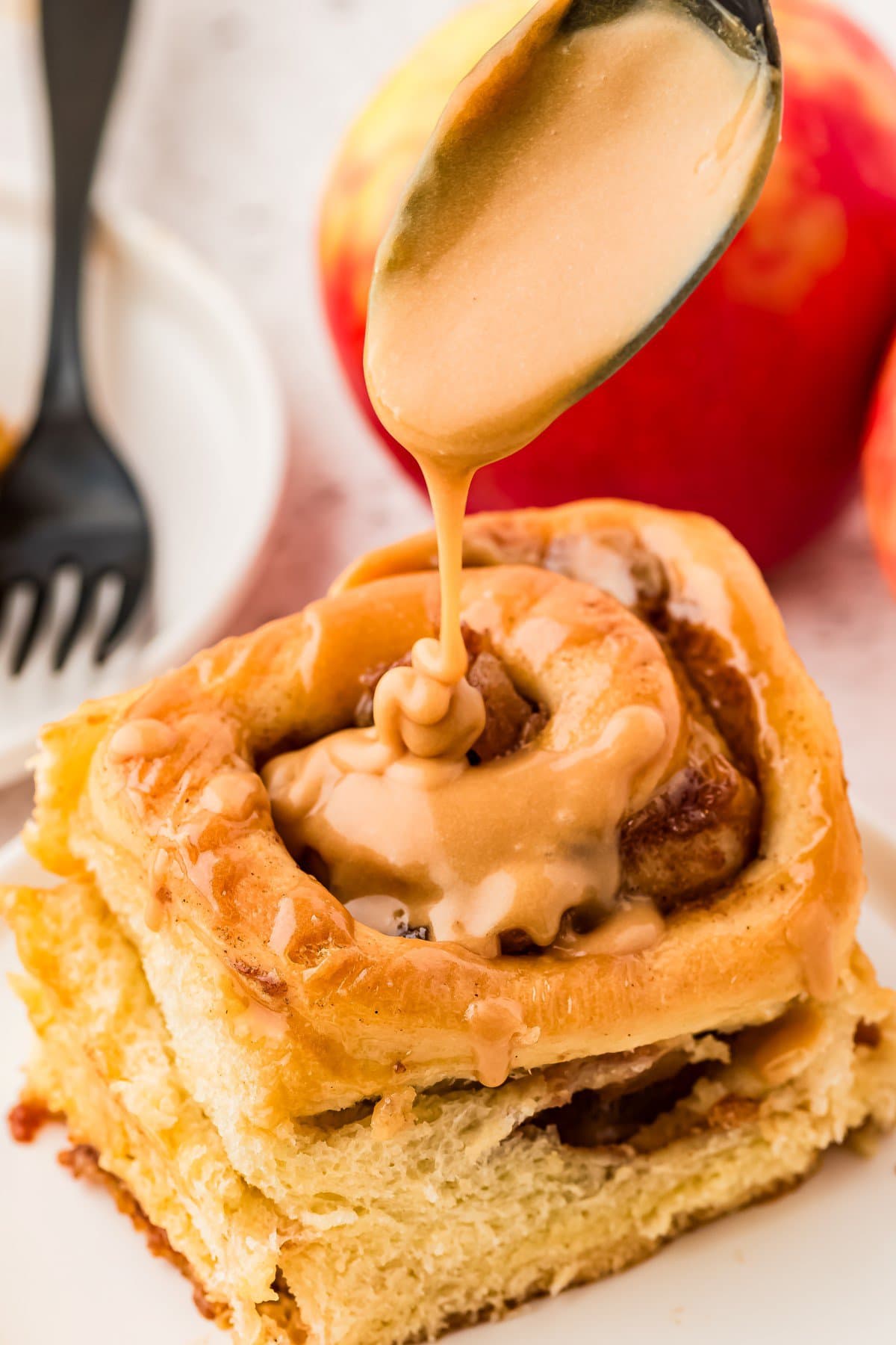 Pouring icing on a cinnamon roll.