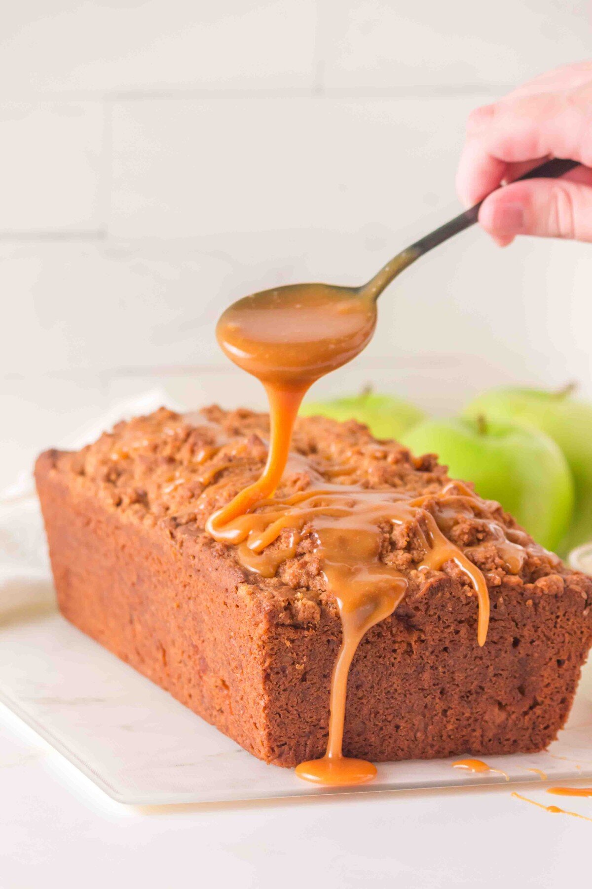 Spooning caramel on the cake.