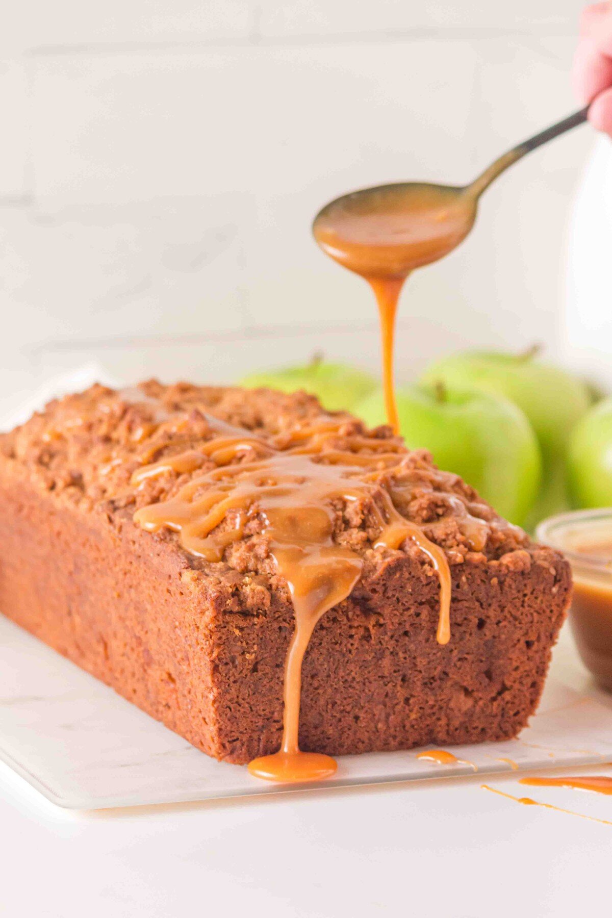 Spooning caramel on the cake.