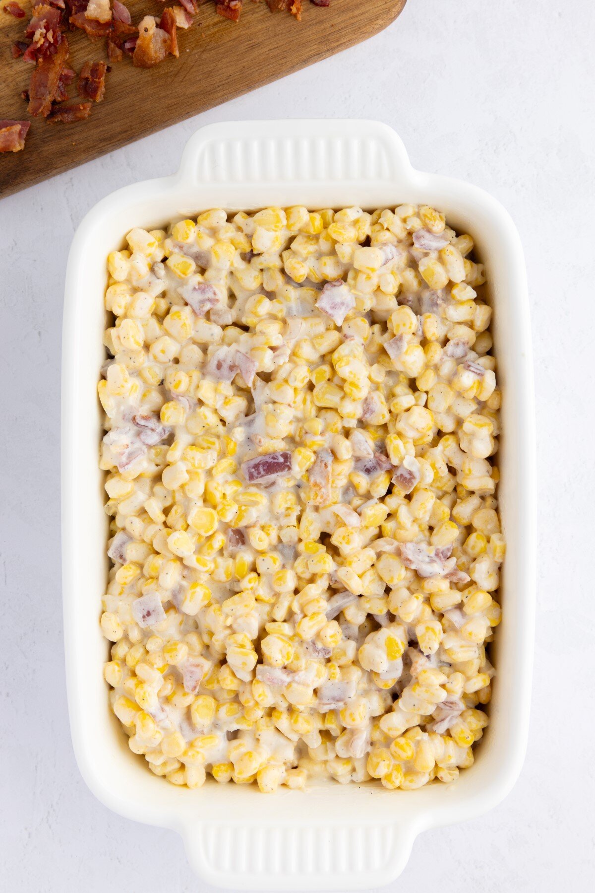 Creamed corn added to casserole dish. 