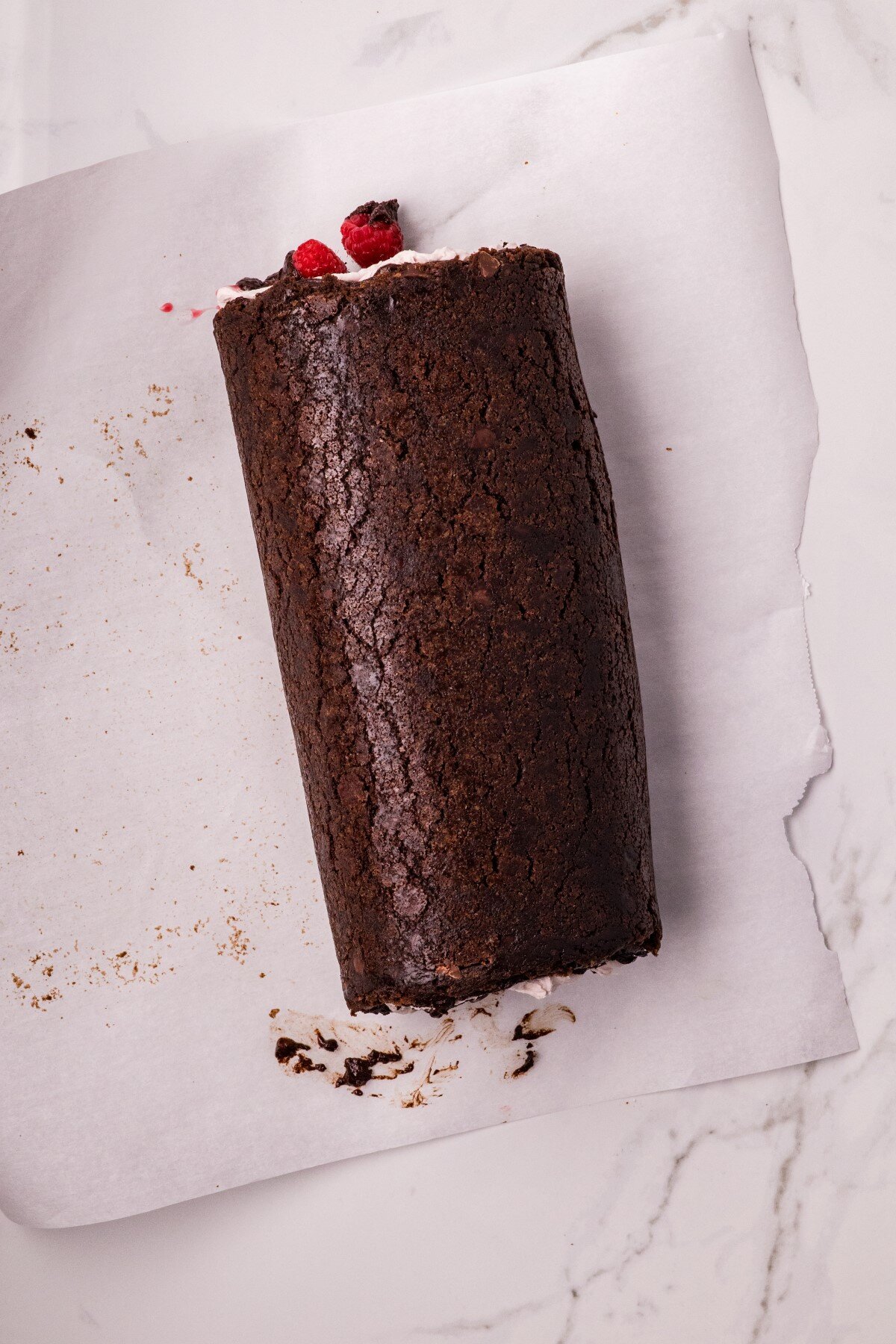 Swiss roll roled up on parchment paper.