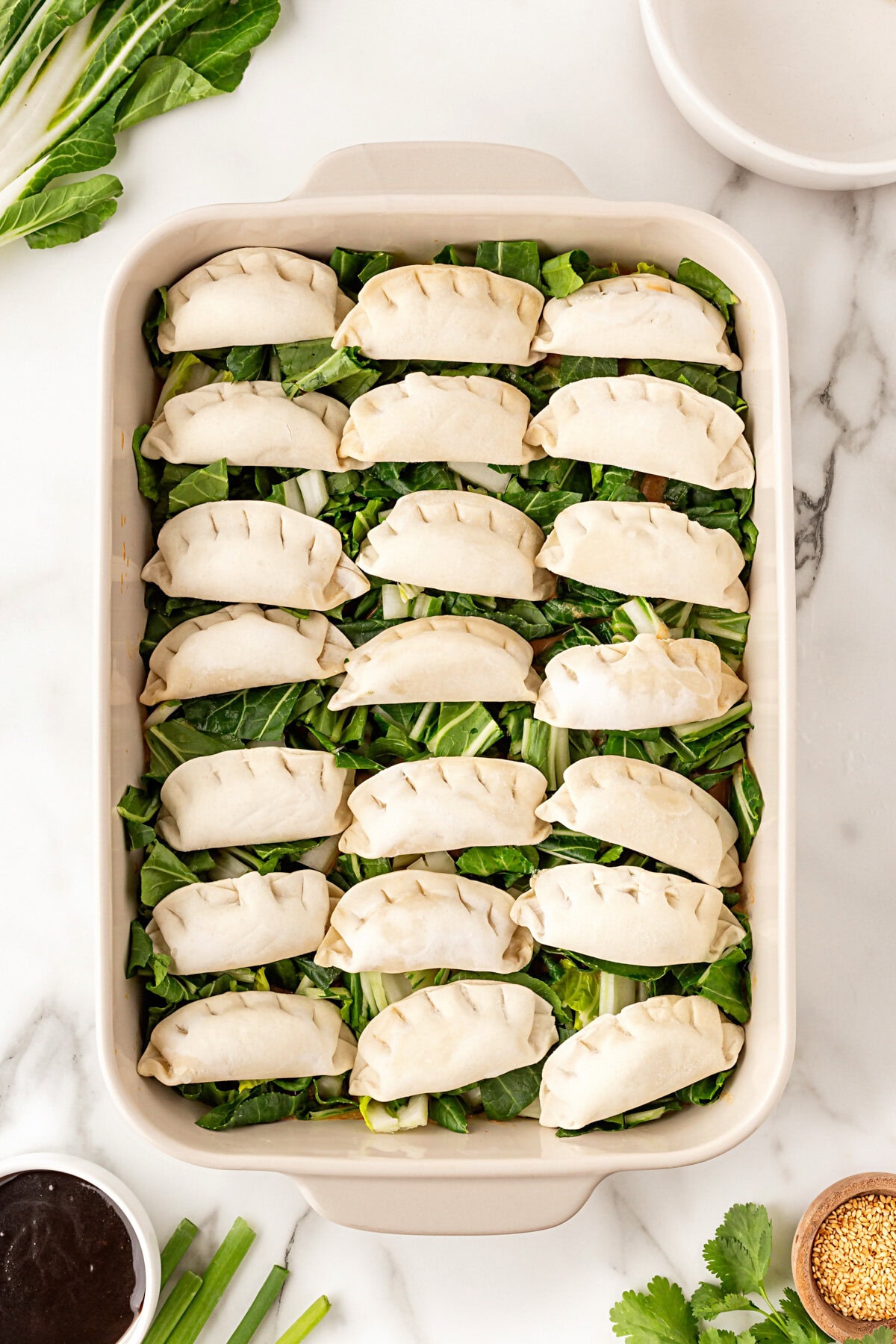 Frozen dumplings layered into the casserole dish.
