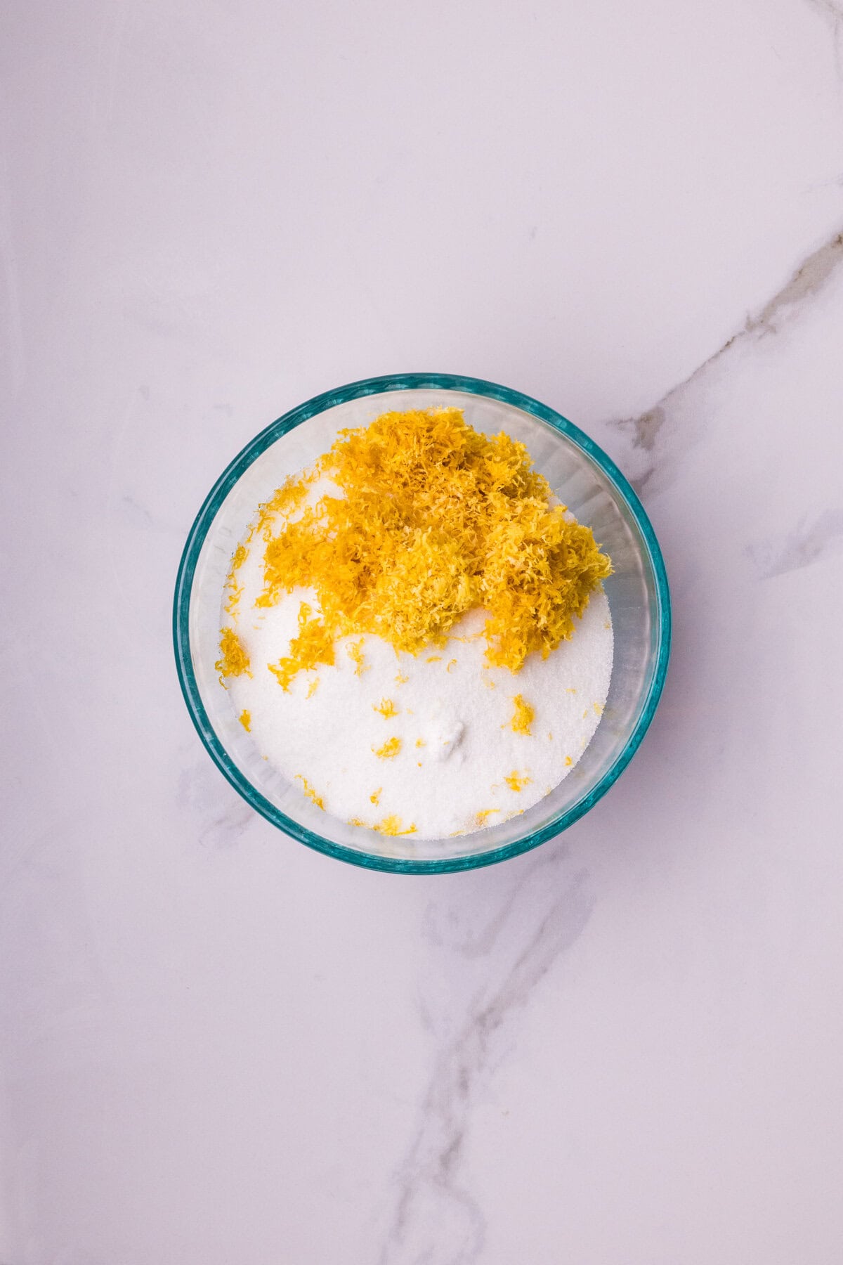 Sugar and lemon zest in a bowl.