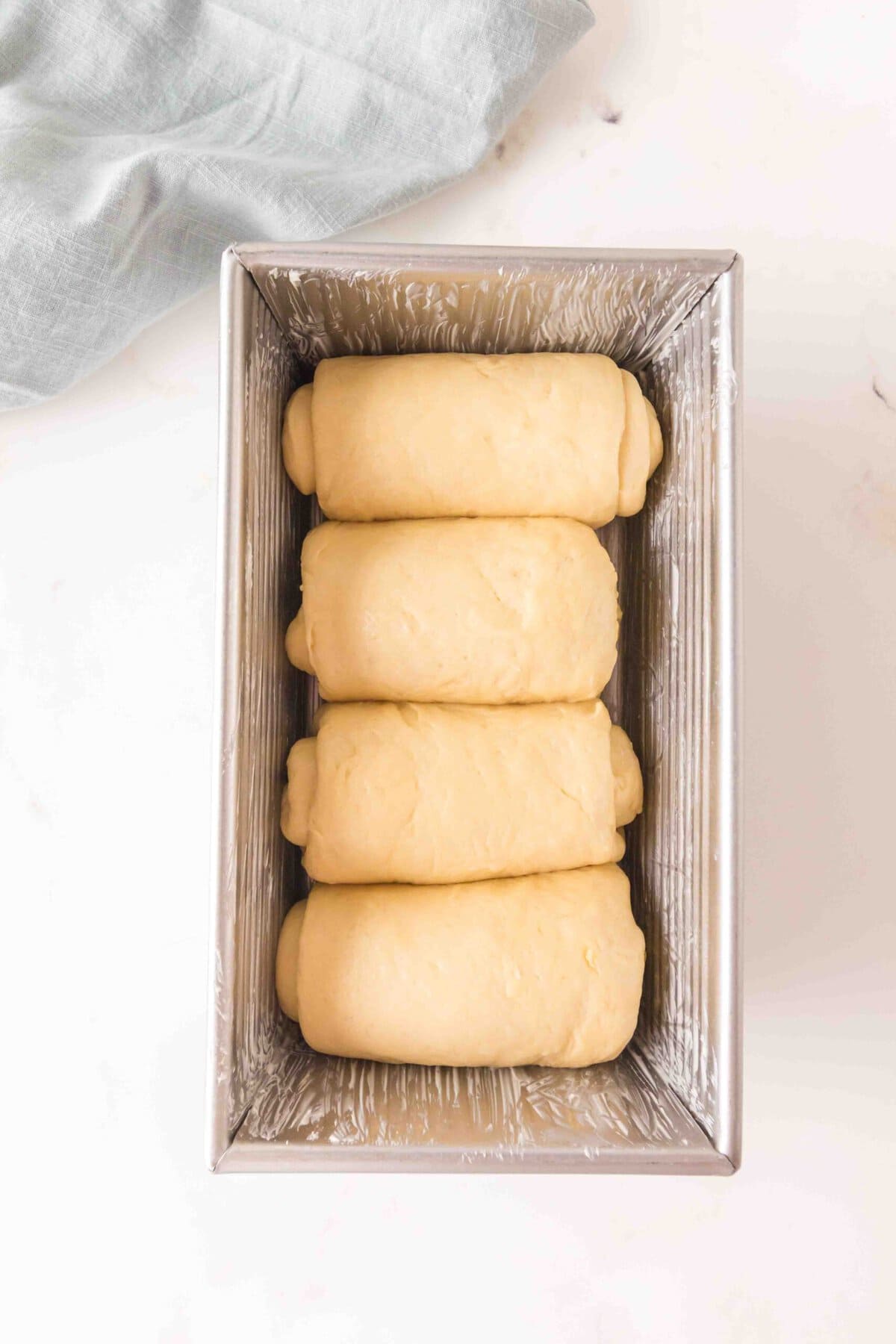 Four sections of dough in pan. 