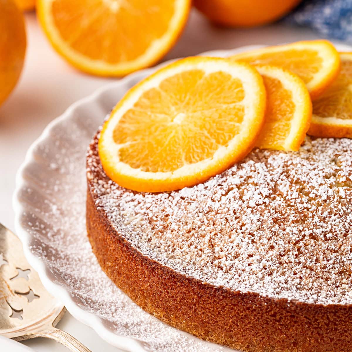 Orange Olive Oil Cake on a plate with orange slices.