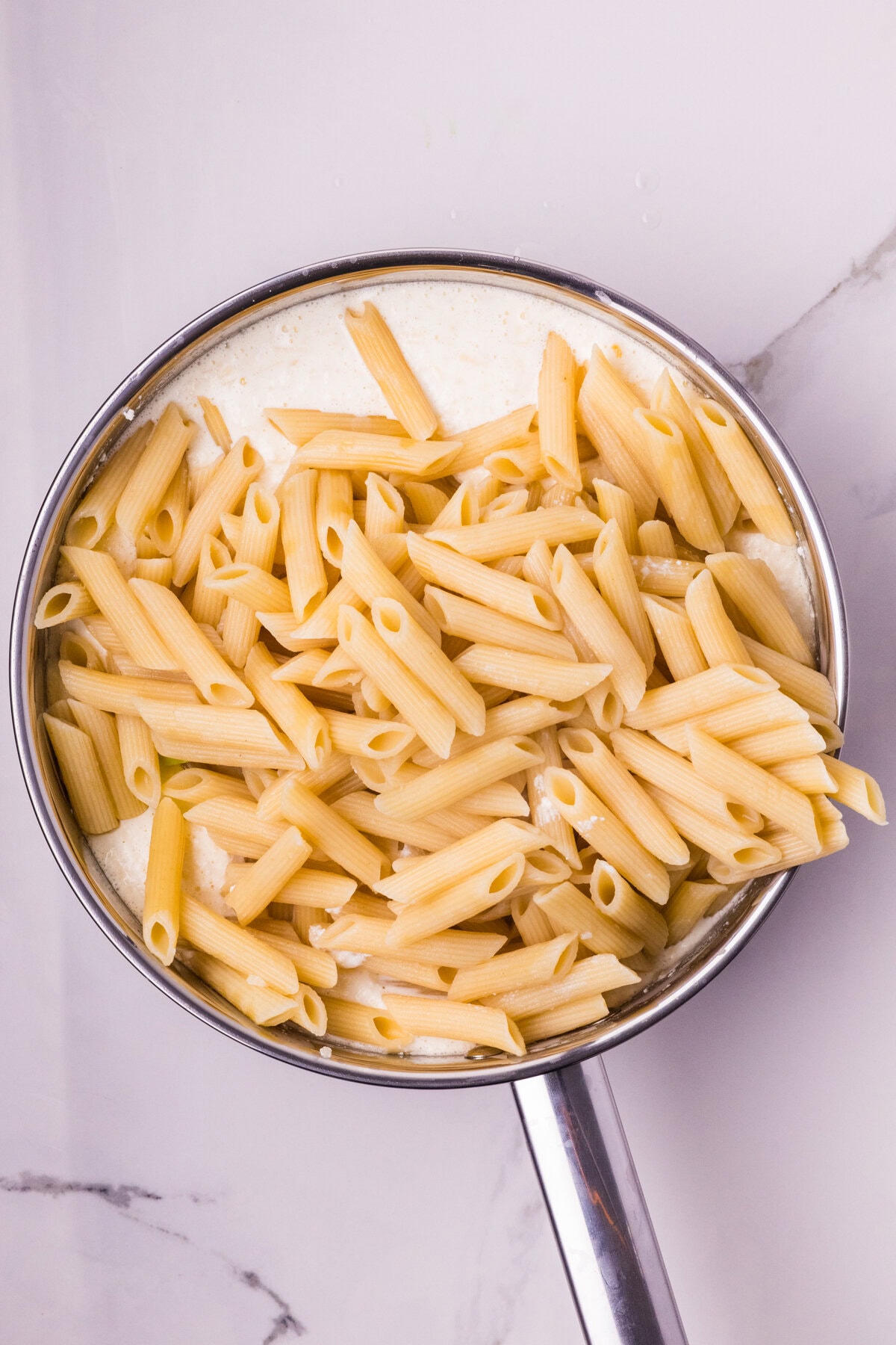 Pasta added to cream sauce. 