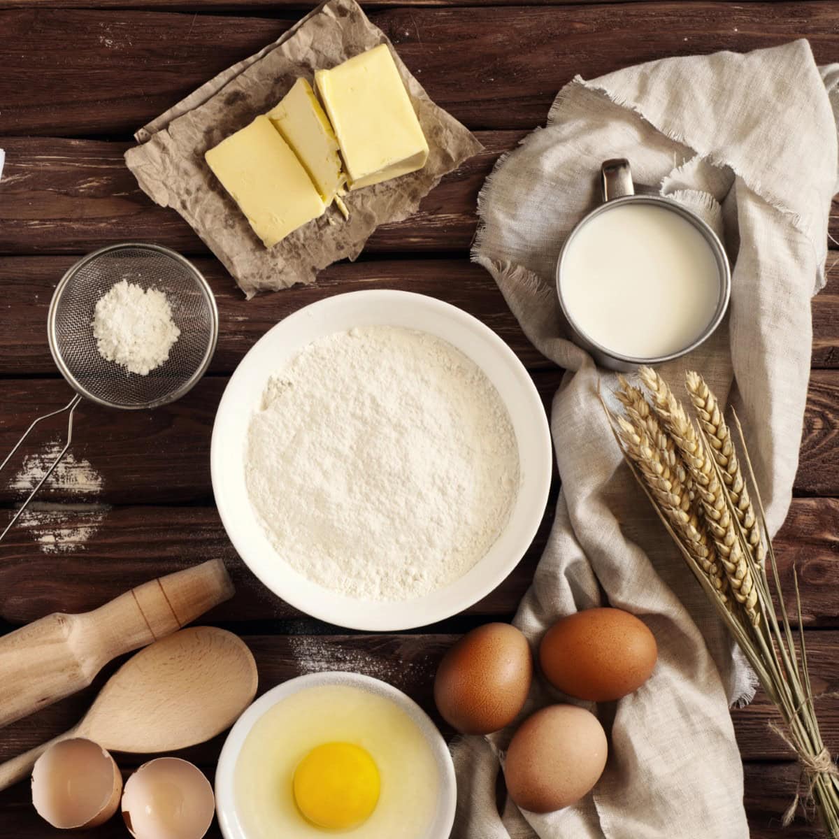 On wooden table flour, egg, butter. Concept ingredients for baking. 