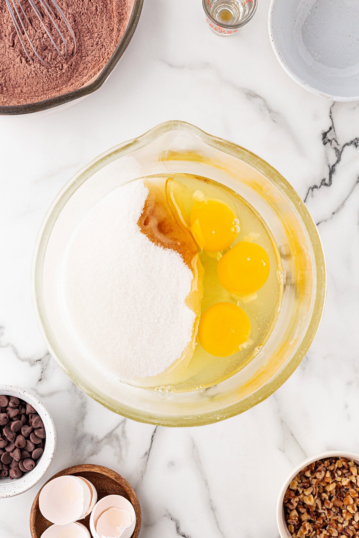 Eggs, vanilla, and sugar in a bowl.