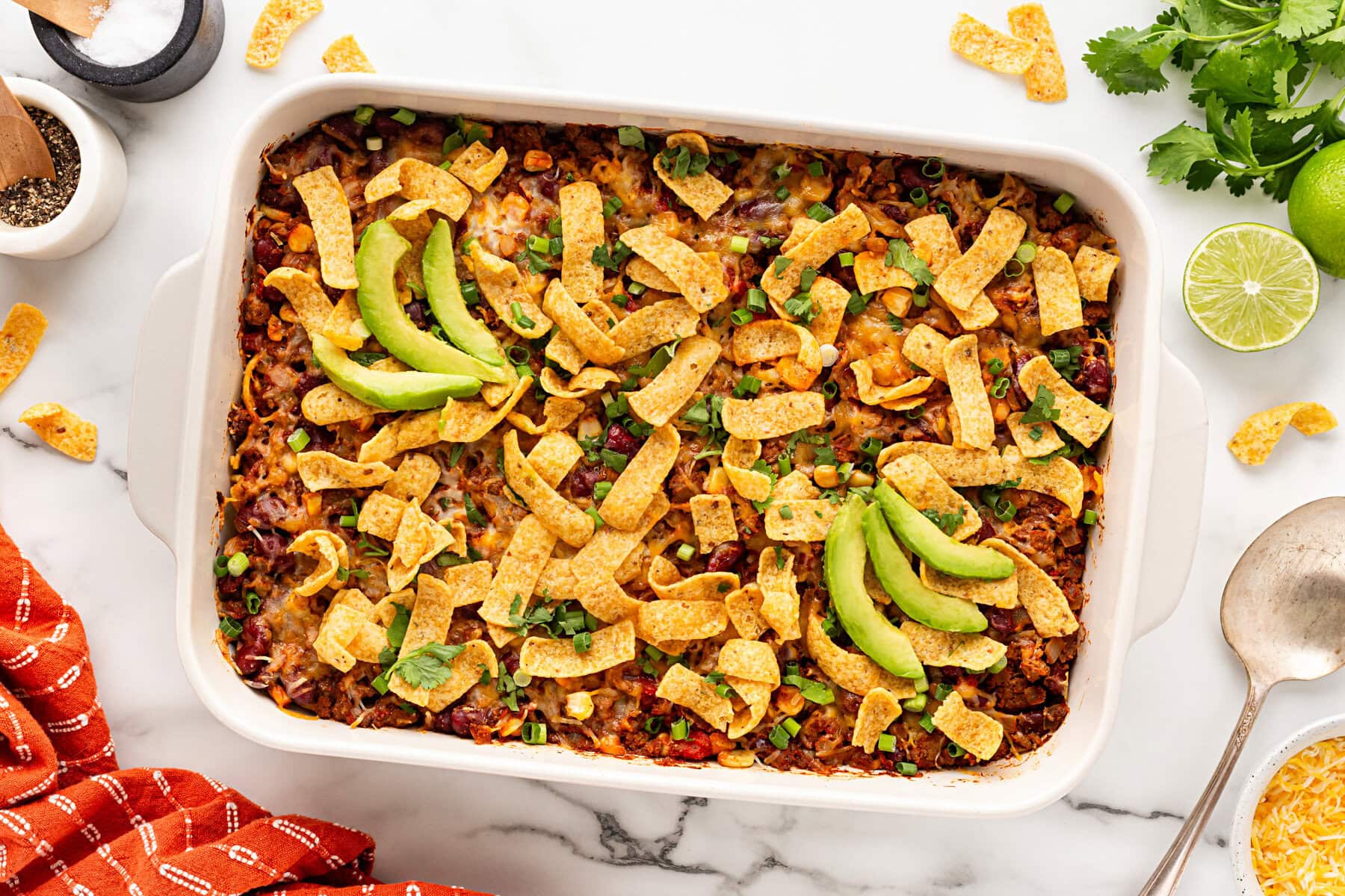 Baked Frito pie with garnishes.