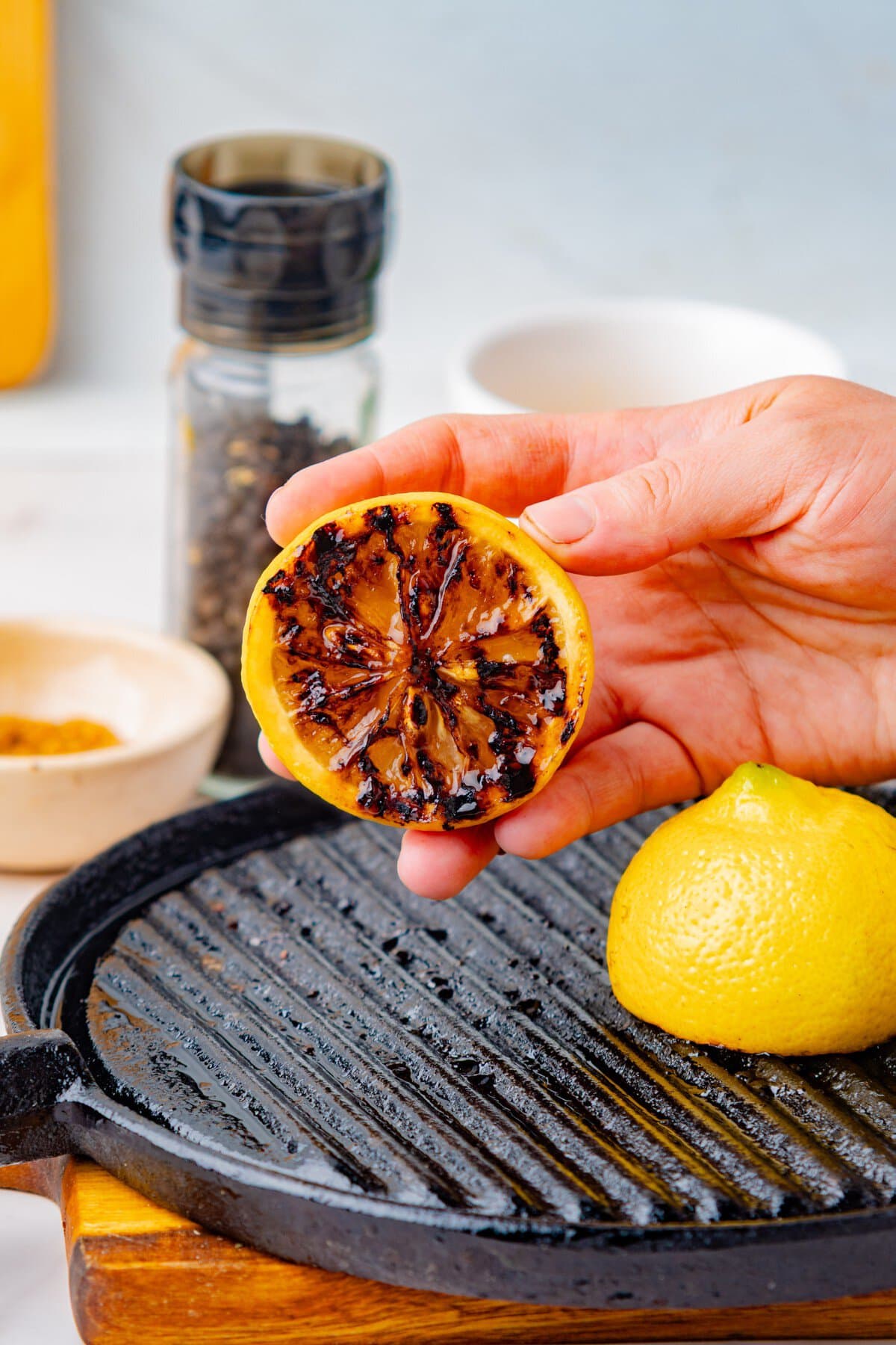 Holding a grilled lemon. 