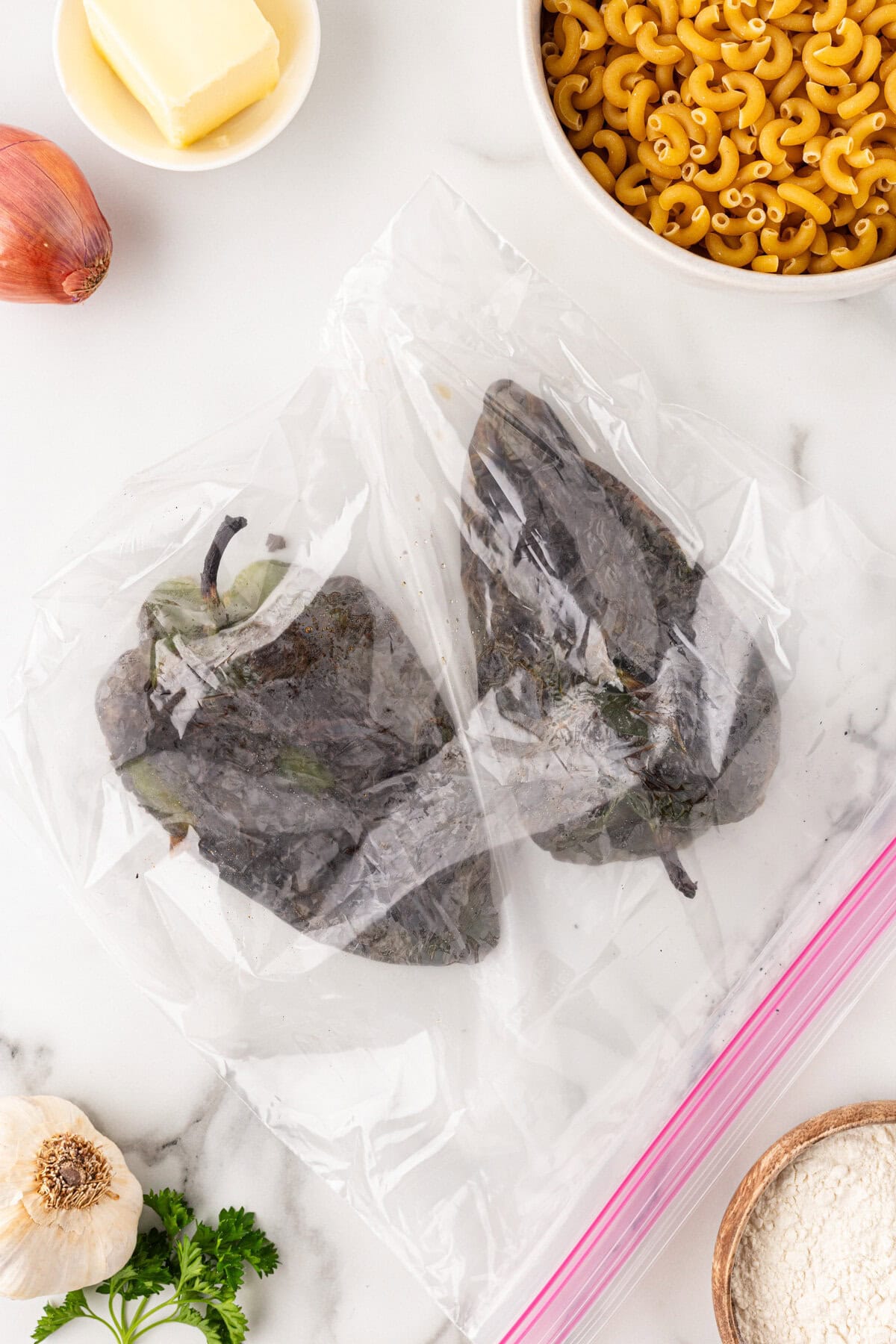 Charred poblano peppers in a bag.