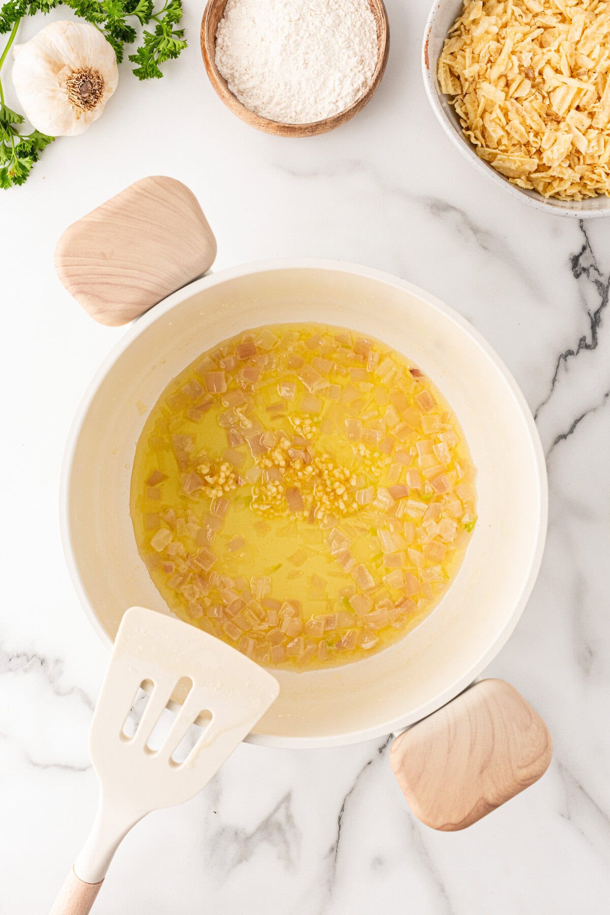 Adding garlic to shallots and butter. 