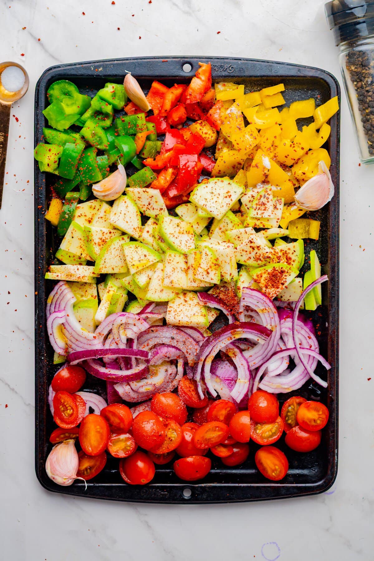 Veggies seasoned on a baking sheet.
