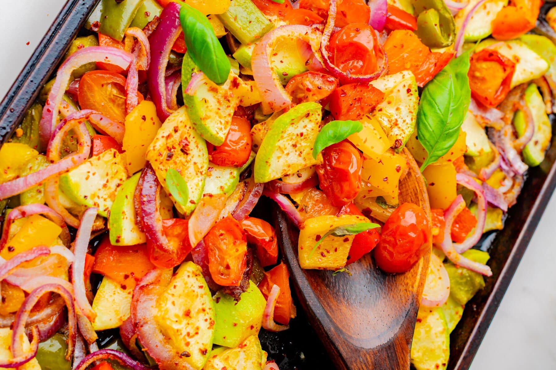 On a sheet pan, cooked with a spoon full of vegetables.
