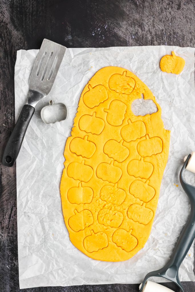 Cutting out orange pumpkins.